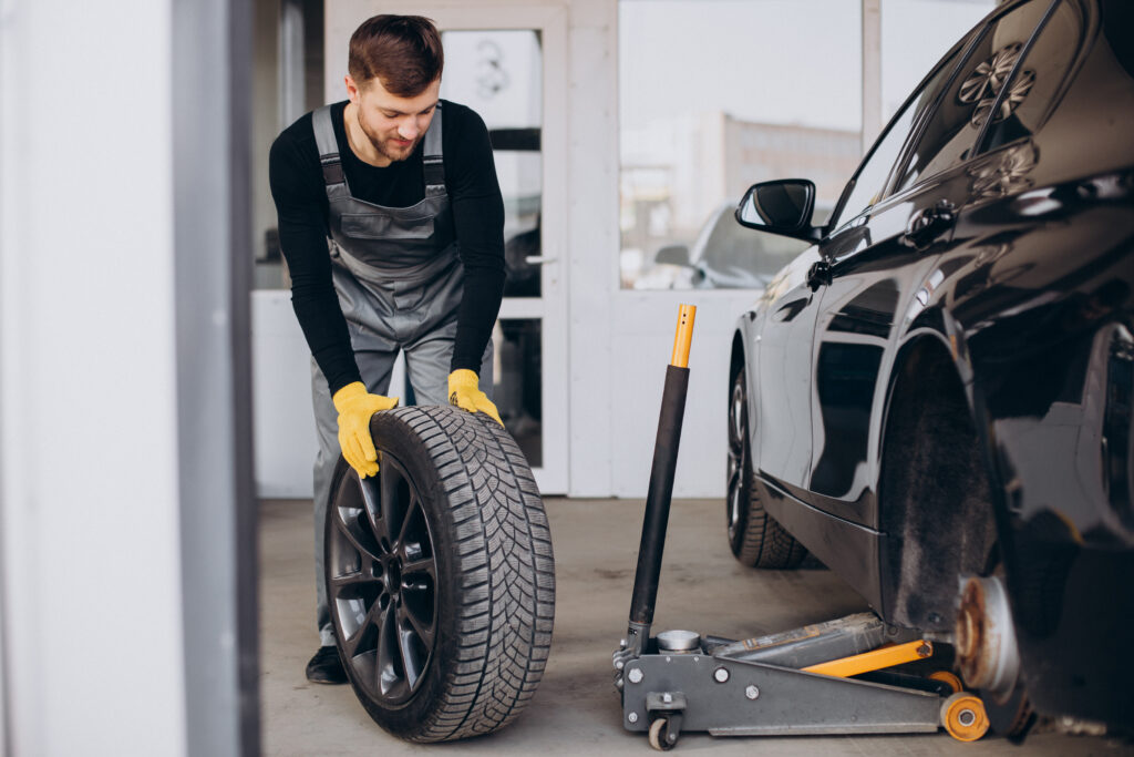 Mobile Tyre Fitting East London technician replacing a car tyre using hydraulic jack during roadside tyre service